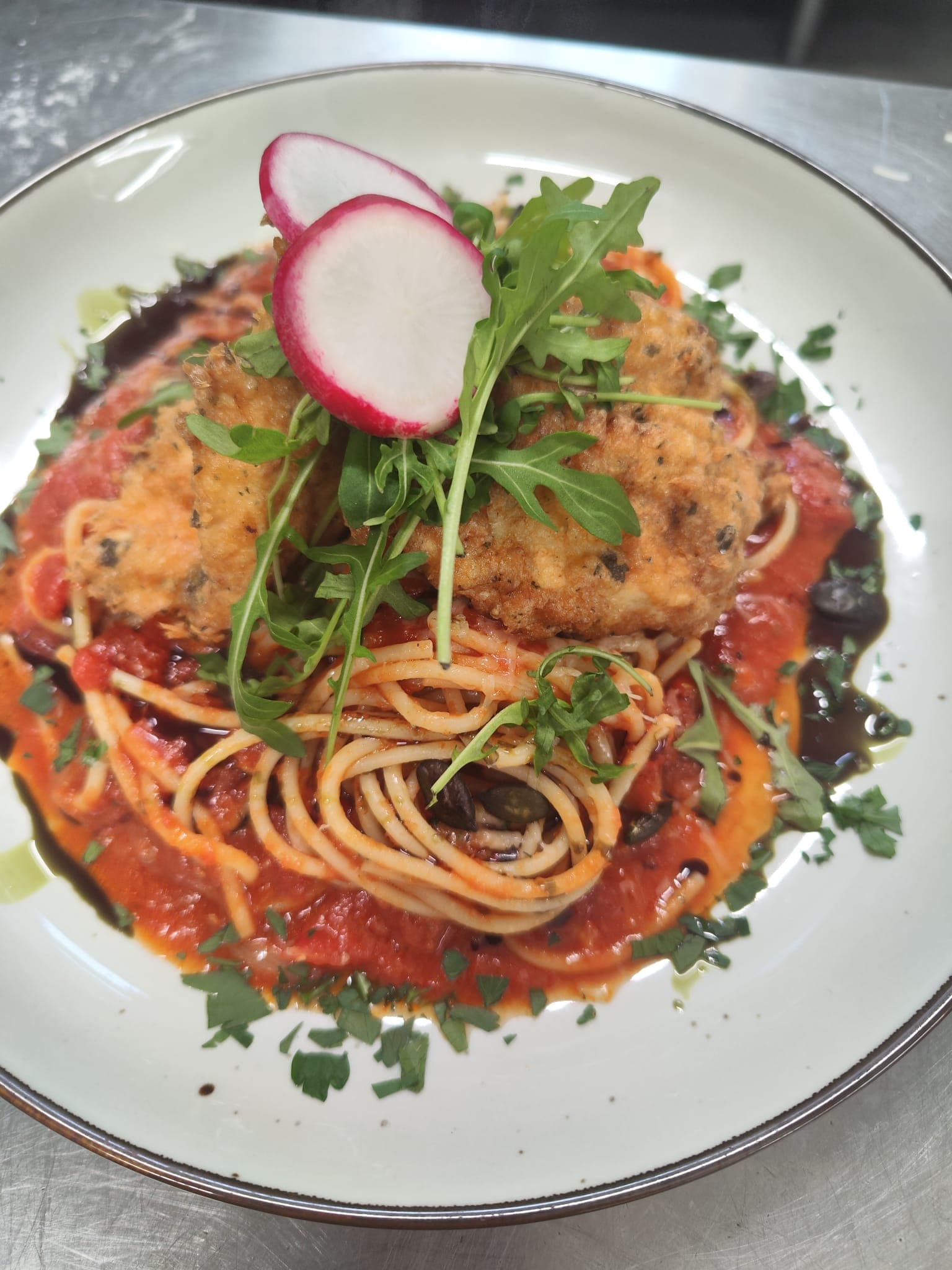 Pasta mit Tomatensauce, Topping und Rucola.