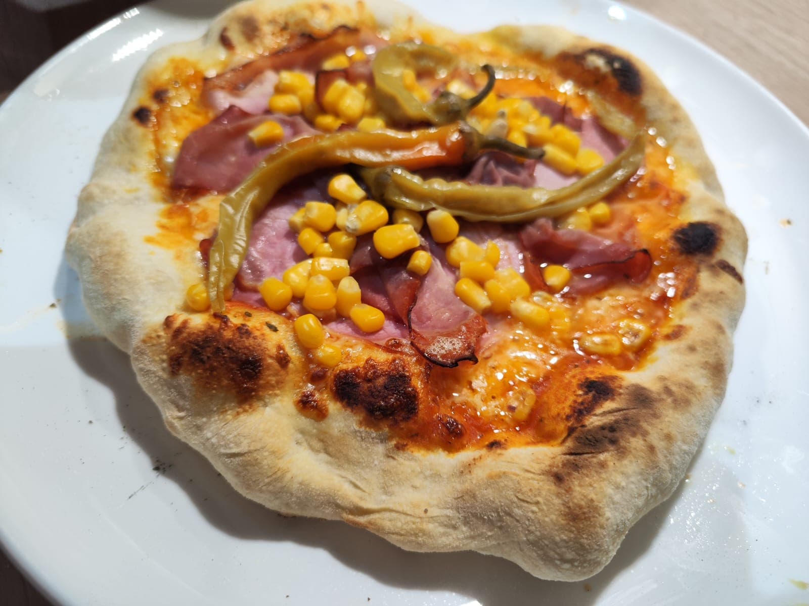 Holzofenpizza mit Mais, Schinken und Peperoni